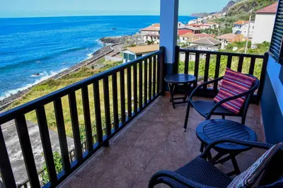 a balcony with chairs and a view of the ocean at Bluehouse Paraiso á beira Mar in São Vicente
