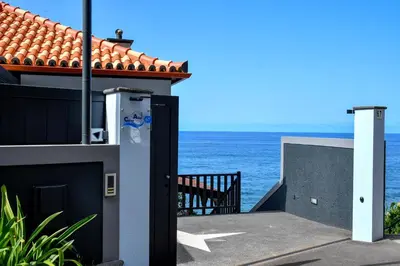 a door to a house with a view of the ocean at Bluehouse Paraiso á beira Mar in São Vicente