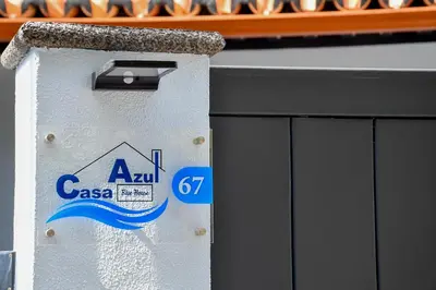 a trash can with a sign on the side of a building at Bluehouse Paraiso á beira Mar in São Vicente