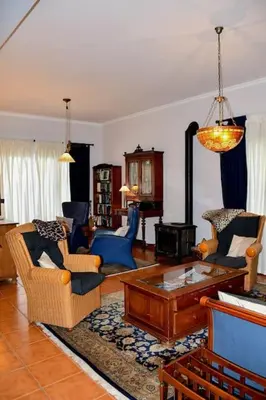 a living room with chairs and a coffee table at Bluehouse Paraiso á beira Mar in São Vicente