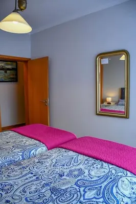 a bedroom with a bed with a mirror on the wall at Bluehouse Paraiso á beira Mar in São Vicente
