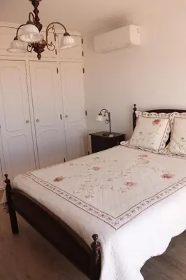 a bedroom with a bed with a white comforter at Luxury Villa with ocean view in Luz