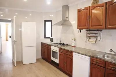 a kitchen with wooden cabinets and a white refrigerator at Luxury Villa with ocean view in Luz