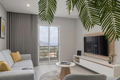 a living room with a couch and a tv at Barreiros III by An Island Apart in Funchal