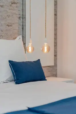 a bedroom with a bed with blue pillow and lights at Barreiros III by An Island Apart in Funchal