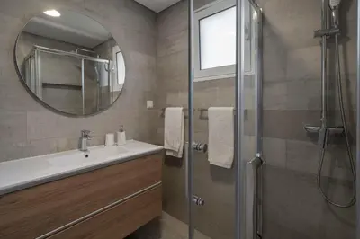 a bathroom with a shower and a sink and a mirror at Barreiros III by An Island Apart in Funchal