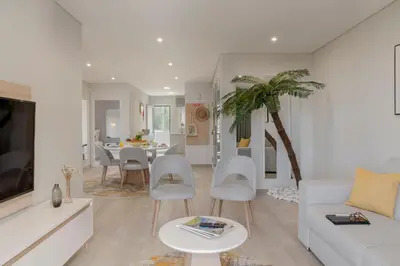 a living room with a white couch and a palm tree at Barreiros III by An Island Apart in Funchal