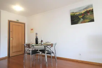 a dining room with a table with chairs and a painting at Yellow Apartment T1 in Funchal
