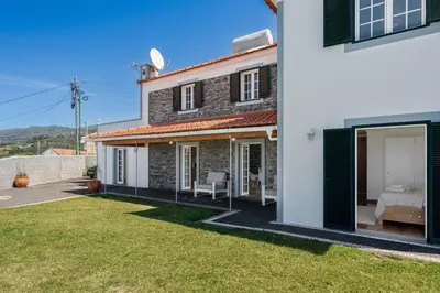 a house with a bedroom and a backyard at OurMadeira - Casa Florenças in Calheta