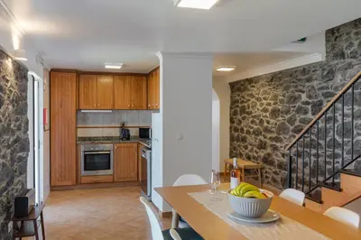 a kitchen with a table with a bowl of bananas on it at OurMadeira - Casa Florenças in Calheta