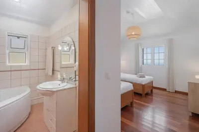 a bathroom with a tub and a sink and a bed at OurMadeira - Casa Florenças in Calheta