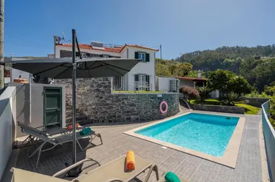 a villa with a swimming pool and a house at OurMadeira - Casa Florenças in Calheta