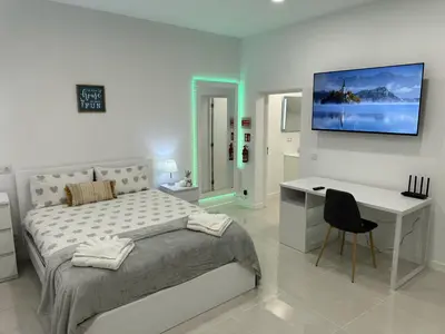 a bedroom with a bed and a desk and a tv at Funchal-Studio-Sleeps4-FreeParking in Funchal