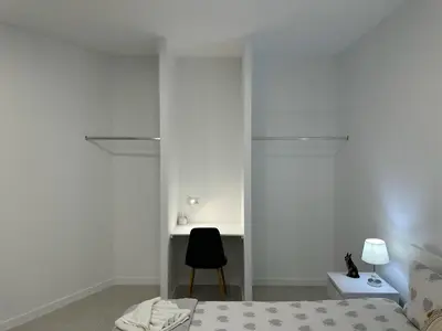 a bedroom with white walls and a bed and a chair at Funchal-Studio-Sleeps4-FreeParking in Funchal