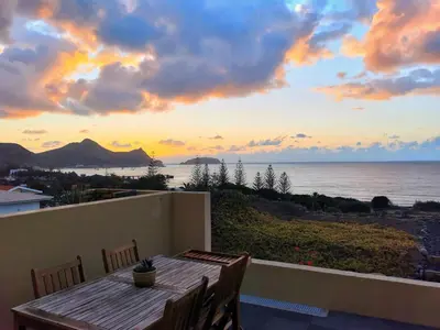 a table on a balcony with a view of the ocean at The Beach House in Porto Santo