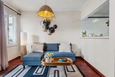 a living room with a blue couch and a table at Catybel by Homie in Funchal