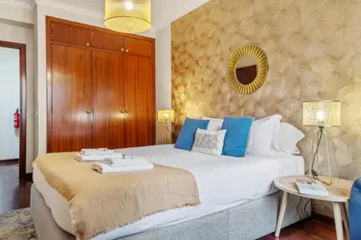 a bedroom with a large bed and a mirror on the wall at Catybel by Homie in Funchal
