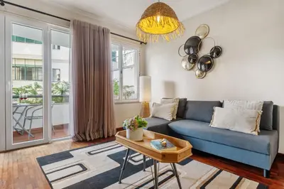 a living room with a blue couch and a table at Catybel by Homie in Funchal