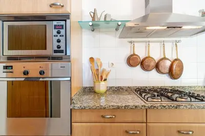 a kitchen with a stove and a microwave at Oceano Azul in Porto Santo