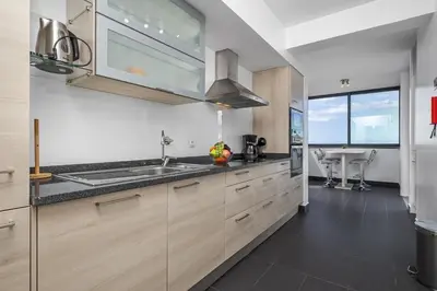 a kitchen with wooden cabinets and a sink at Cote D Atlantique by Homie in Caniço