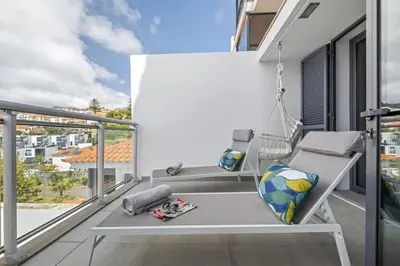 a swinging bench on a balcony with a view at Cote D Atlantique by Homie in Caniço