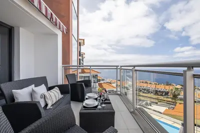 a balcony with chairs and a table on a building at Cote D Atlantique by Homie in Caniço