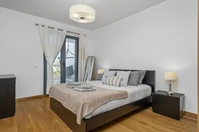 a white bedroom with a large bed and a window at Cote D Atlantique by Homie in Caniço