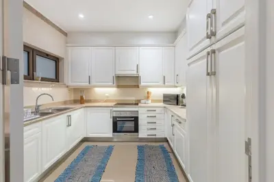 a kitchen with white cabinets and a refrigerator at The Suite QM in Funchal