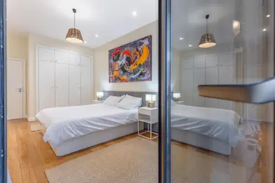 a bedroom with two beds and a mirror at The Suite QM in Funchal
