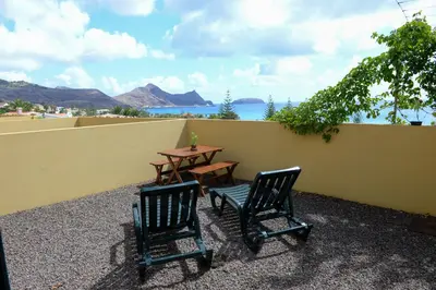 two chairs and a table on a patio with a table at Bela Vista Capazi in Porto Santo