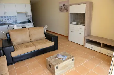 a living room with a couch and a kitchen at Bela Vista Capazi in Porto Santo