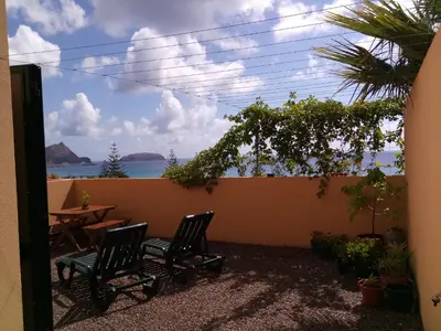 a patio with two chairs and a table and a view of the ocean at Bela Vista Capazi in Porto Santo