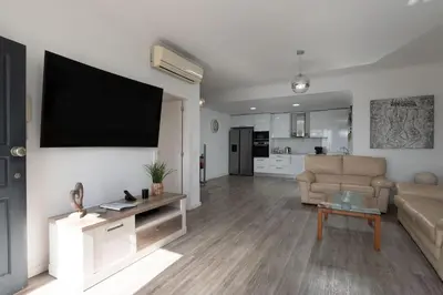 a living room with a couch and a television on a wall at Villa Liana by LovelyStay in Ponta do Sol