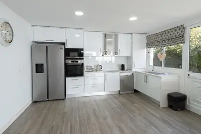 a kitchen with white cabinets and a refrigerator at Villa Liana by LovelyStay in Ponta do Sol