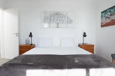 a bedroom with a large white bed and two dressers at Villa Liana by LovelyStay in Ponta do Sol