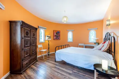 a bedroom with orange walls and a bed and a dresser at Casa Azul in Luz