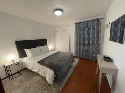 a bedroom with a bed and a table in it at Pereira Place - Cottage in São Vicente