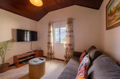 a living room with a couch and a tv at Pereira Place - Cottage in São Vicente