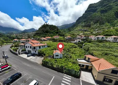 a view of a village with a red sign on a hill at Pereira Place - Cottage in São Vicente