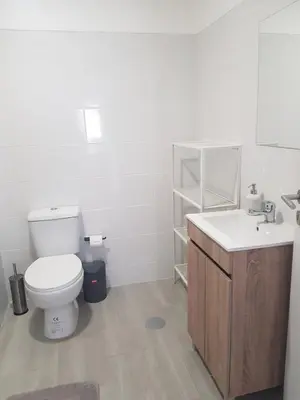 a white bathroom with a toilet and a sink at Apartamento Cristino in Luz