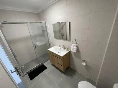 a bathroom with a shower and a sink and a toilet at Apartamento Don Tenório com piscina Sagres in Sagres
