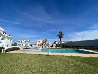 a swimming pool in a yard next to a building at Apartamento Don Tenório com piscina Sagres in Sagres