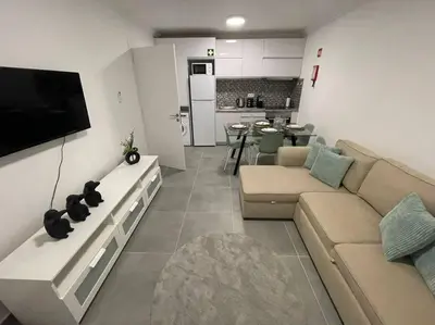 a living room with a couch and a flat screen tv at Apartamento Don Tenório com piscina Sagres in Sagres