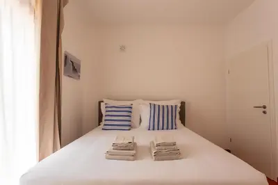 a bedroom with a white bed with towels on it at Casa da praia in Carrapateira
