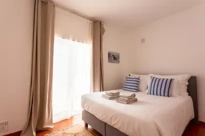 a bedroom with a bed with a large window at Casa da praia in Carrapateira