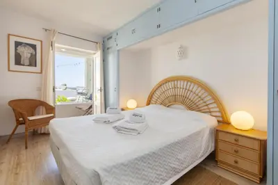 a bedroom with a large white bed and a window at C22 - Beco do Poço Beach Townhouse in Praia da Luz in Luz
