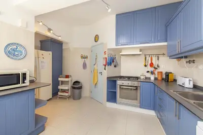 a kitchen with blue cabinets and a sink and a microwave at C22 - Beco do Poço Beach Townhouse in Praia da Luz in Luz