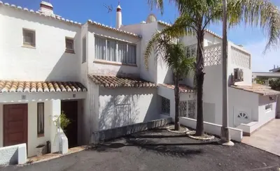 a white house with a palm tree in front of it at C22 - Beco do Poço Beach Townhouse in Praia da Luz in Luz