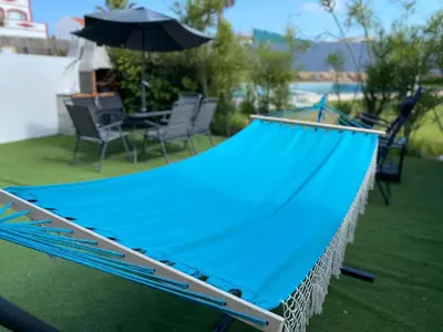a blue tarp on a patio with chairs and an umbrella at Casa com terraço e piscina Sagres in Sagres