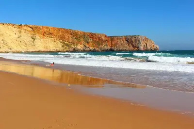 a person walking on a beach next to the ocean at Blue Room in Pedralva